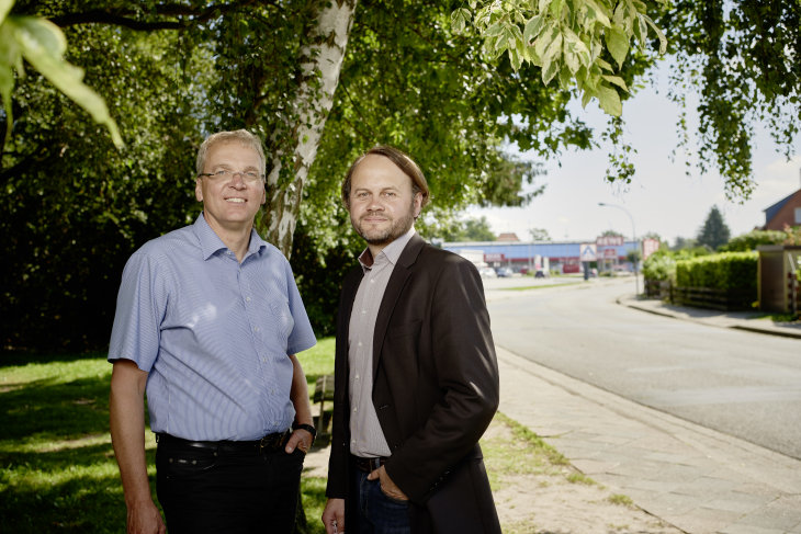 Jens Böther (links) und Dr. Markus Groth (rechts) in Bleckede. Die Straße, die im Hintergrund zu sehen ist, ist bei Starkregen schnell überflutet. Die Feuerwehr pumpte im Mai 2017 die Keller und Tiefgaragen der Stadt aus und Gullis wurden geöffnet, um die Bahn wieder befahrbar zu machen.
Foto: Hereon/ Christian Schmid Jens Böther und Dr. Markus Groth in Bleckede.