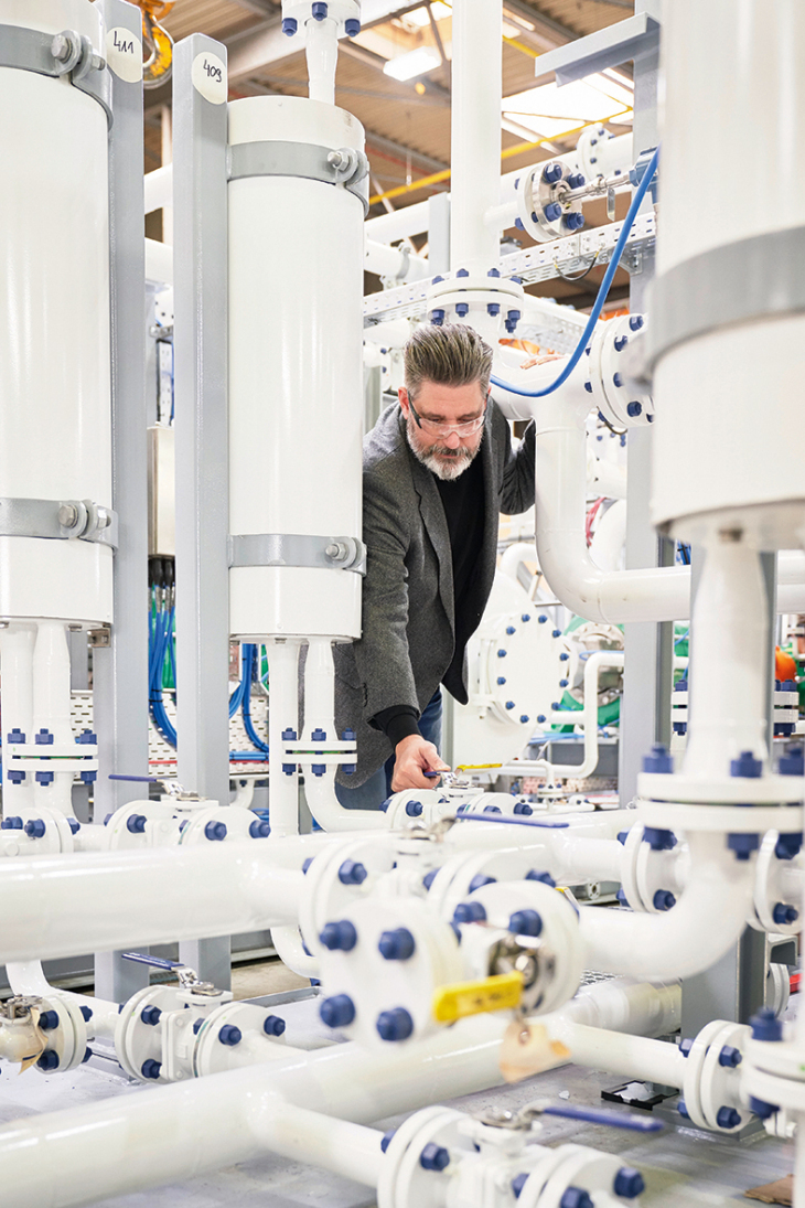 The membranes from Geesthacht are in the high white containers. Photo: Hereon/Christian Schmid Henning Scheel at the membrane plant