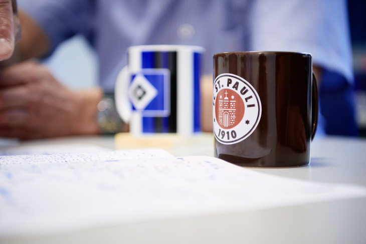 Gute Kooperation trotz unterschiedlicher Vorlieben: HSV-Fan Jens Böther macht es nichts aus, wenn Markus Groth lieber aus seiner Pauli-Tasse trinkt.
Foto: Hereon/ Christian Schmid 2 Tassen, die eine bedruckt mit dem Schalke Logo, die andere mit dem St. Pauli Logo